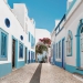 QStreet in fishermen village with white and blue houses and typical Portuguese pavement in Olhao, Algarve region portugal